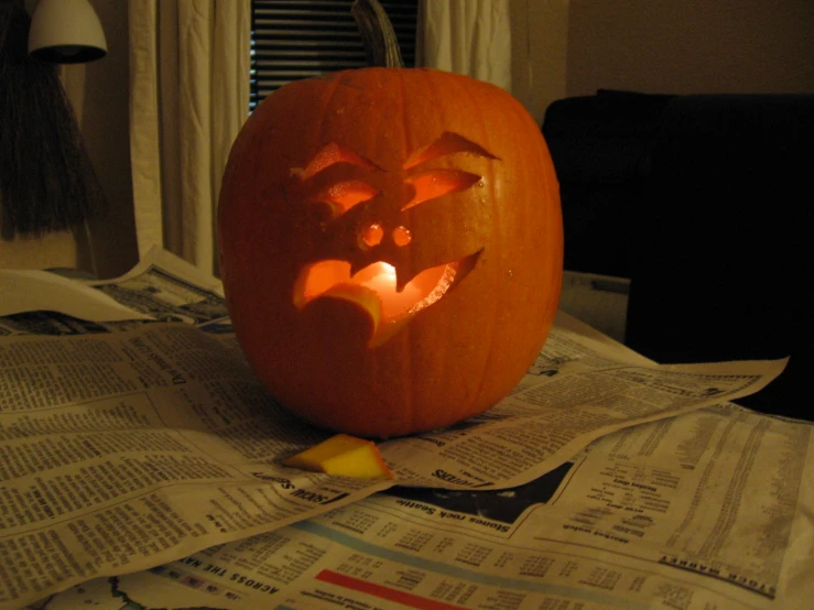 an illuminated pumpkin with the face carved from paper