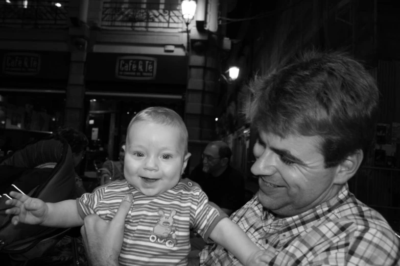 a man holding a little boy while standing next to him