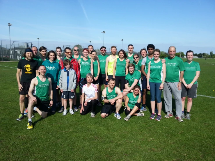 a group of men and women are standing on a soccer field