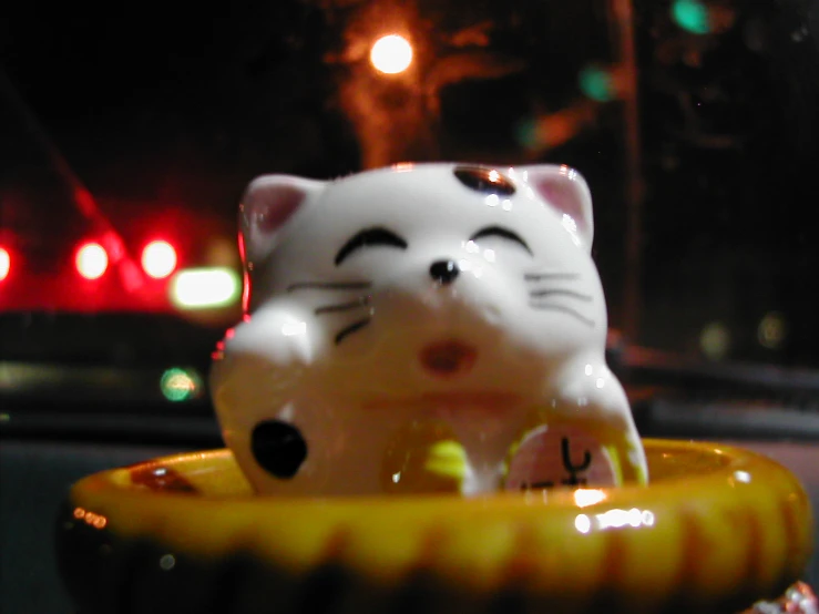 cat figurine on saucer in car window