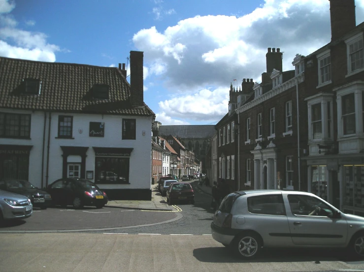 a car driving down the road past a row of buildings