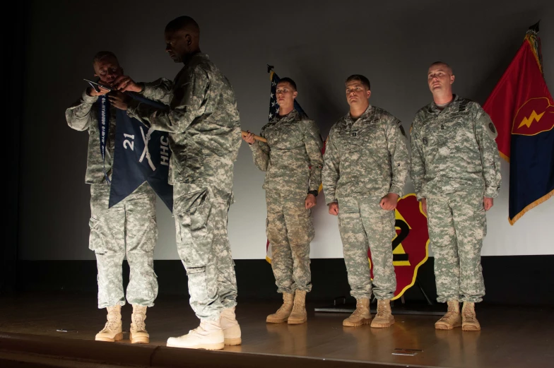 two men are placing the american flag on two soldiers'uniform