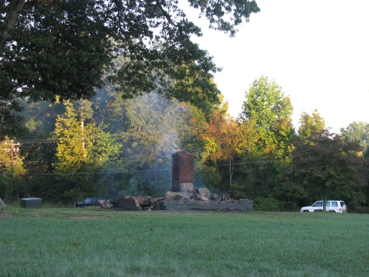 an open field with a fire place and a truck