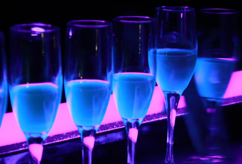 blue wine is lined up in glasses