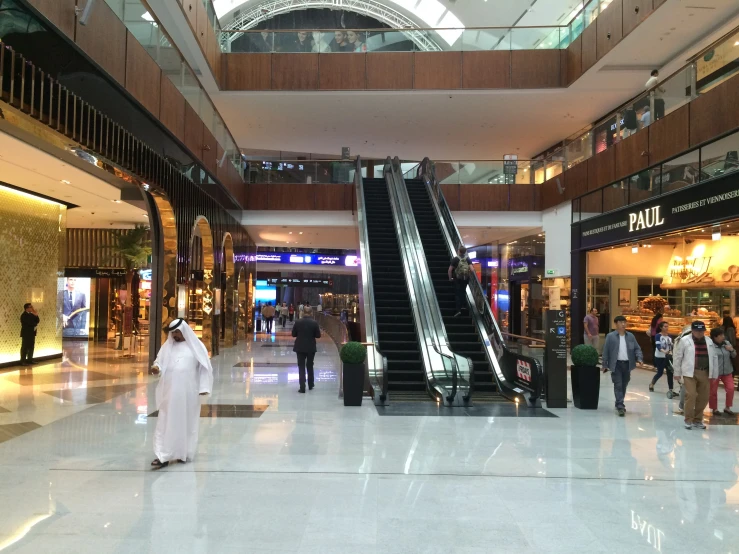 people walking down the escalator of a shopping mall