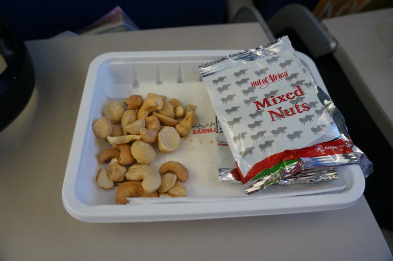 a plastic container that has a bag and nuts in it