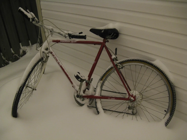 a red bike is covered with snow from a winter storm