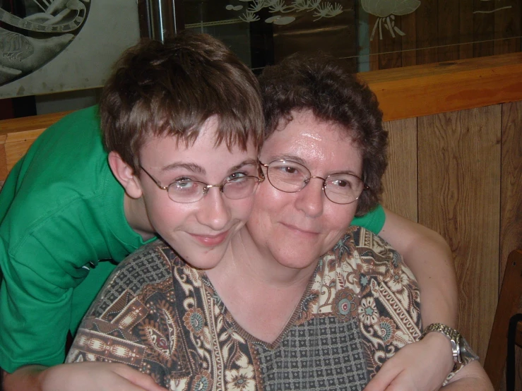 two people pose for a picture in a cafe