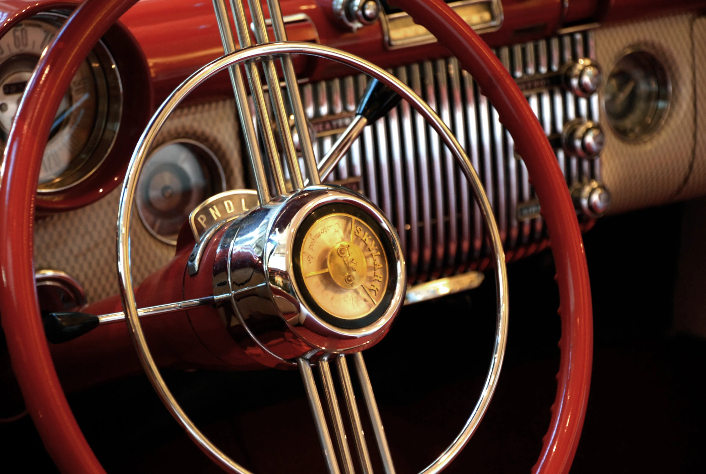 a red steering wheel and dashboard of an old car