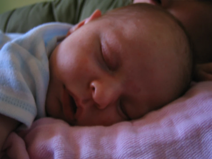 the small baby sleeps on a pink blanket