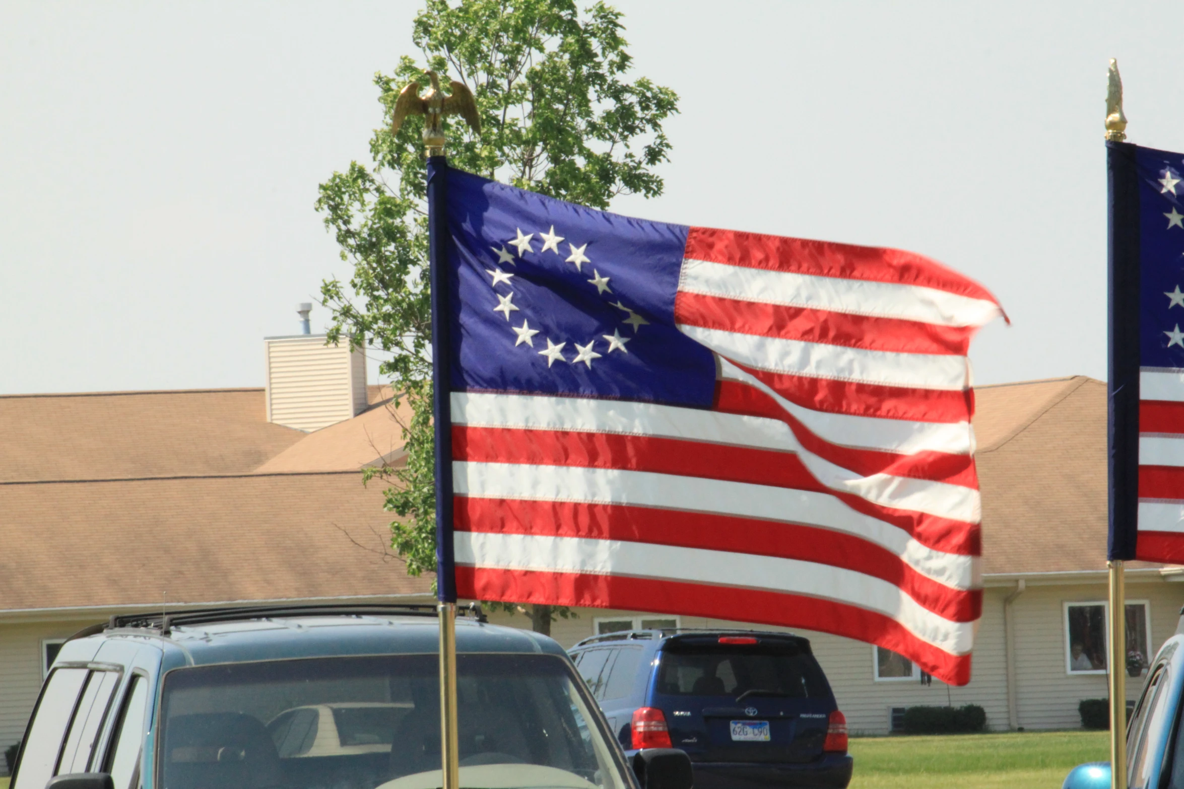 an american flag flying in the wind near a motel room