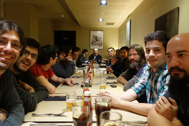 a bunch of people sitting around tables at a long table