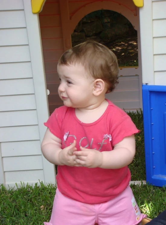 a toddler girl playing outside in the grass