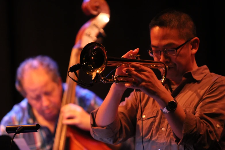 two men are playing on trumpets together at night