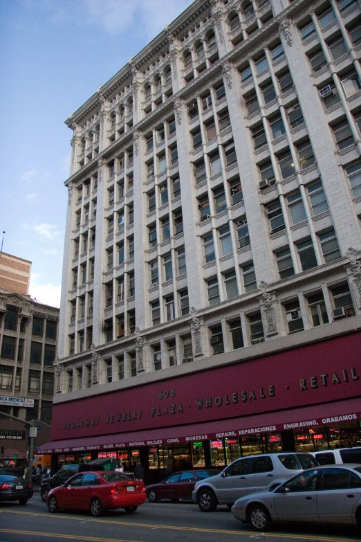 a very tall building with many windows and cars parked in front