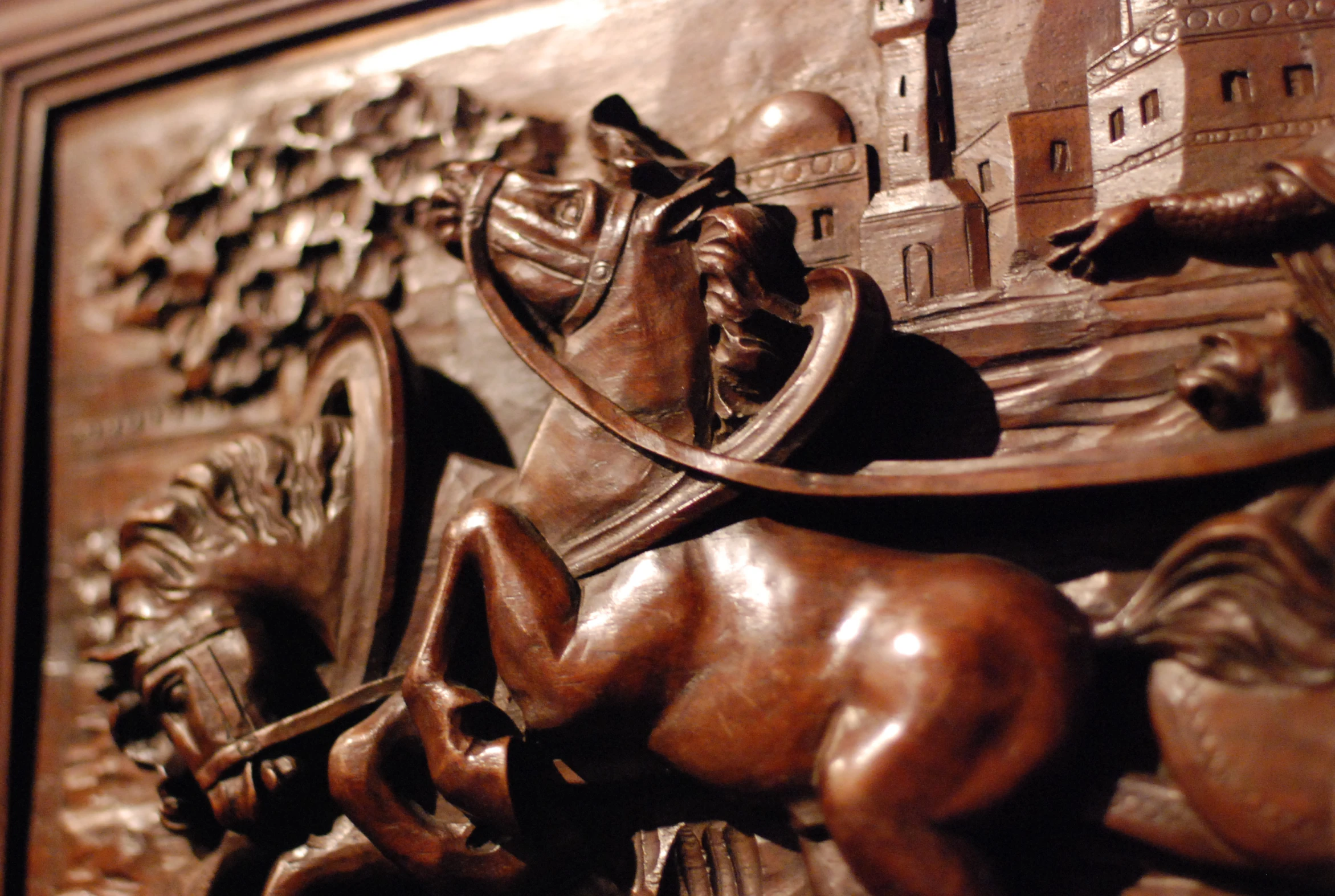 a wooden carving showing the scene of a knight and his horse