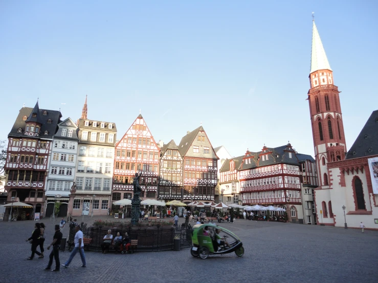 a square with a small vehicle on the center and a very tall tower