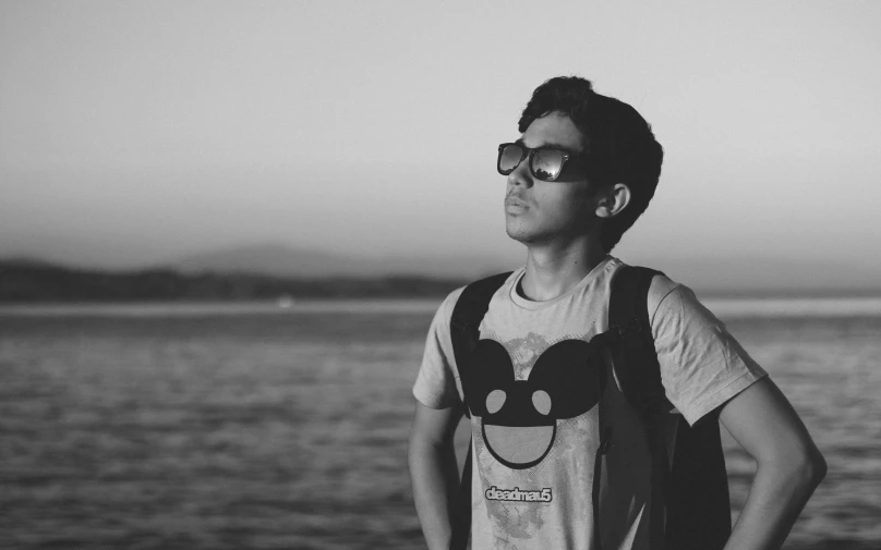 a man that is wearing glasses next to the water