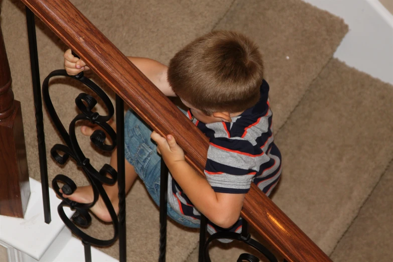 a boy is climbing the stairs holding his hands