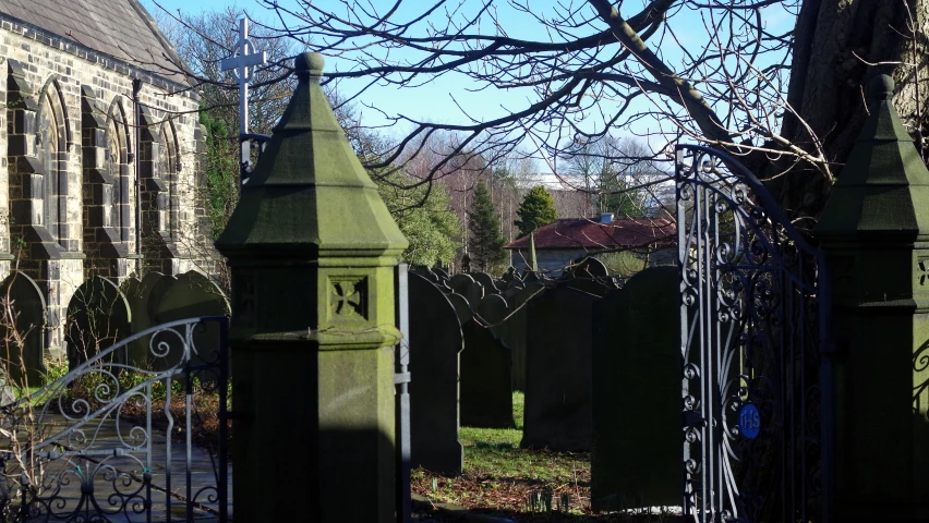 two graves in a cemetery, with old architecture behind them