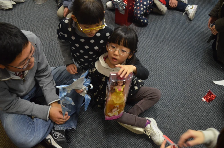 two s are holding up plastic bottles and looking at them