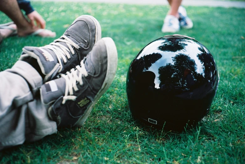 a helmet and a pair of legs on the grass