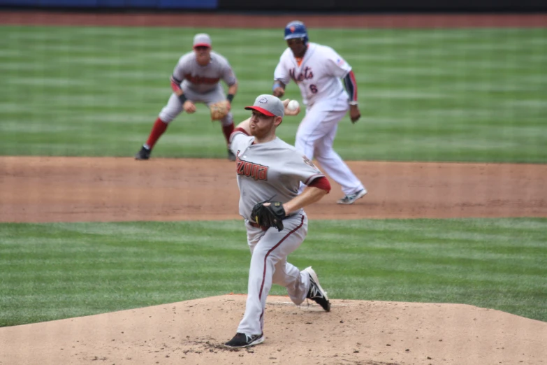 baseball pitcher in motion throwing ball from mound