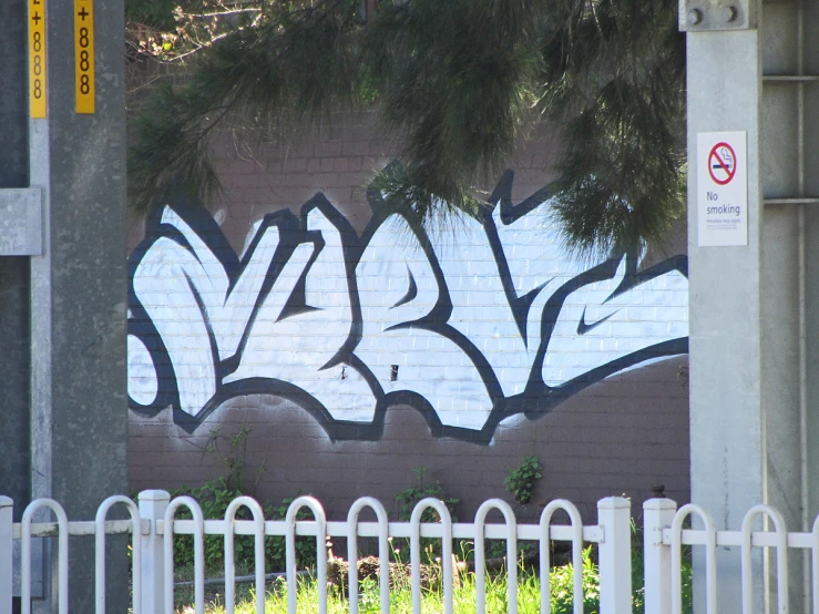 a brick wall with white paint and graffiti