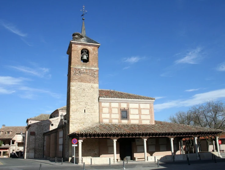 a brick clock tower sitting next to a small town