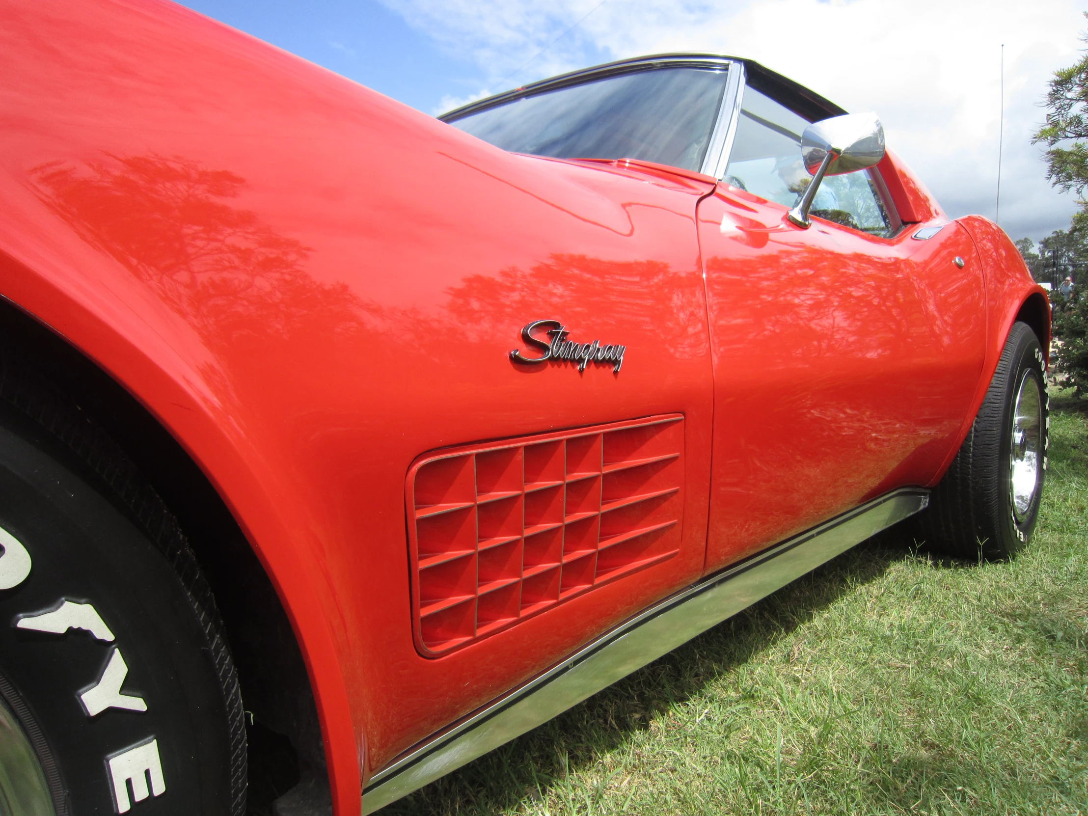 an orange car is sitting out on the grass