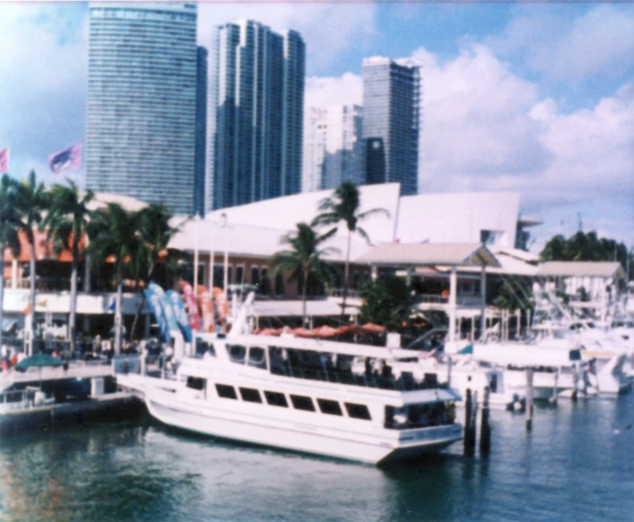 a white boat sitting in the water next to many tall buildings