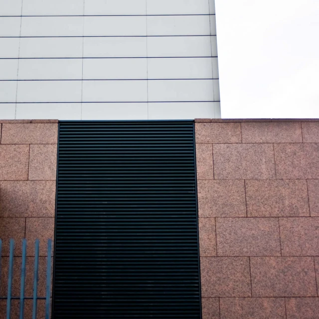 a clock on a brick building and some metal bars