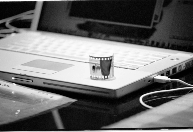 a drink sitting on top of a laptop computer