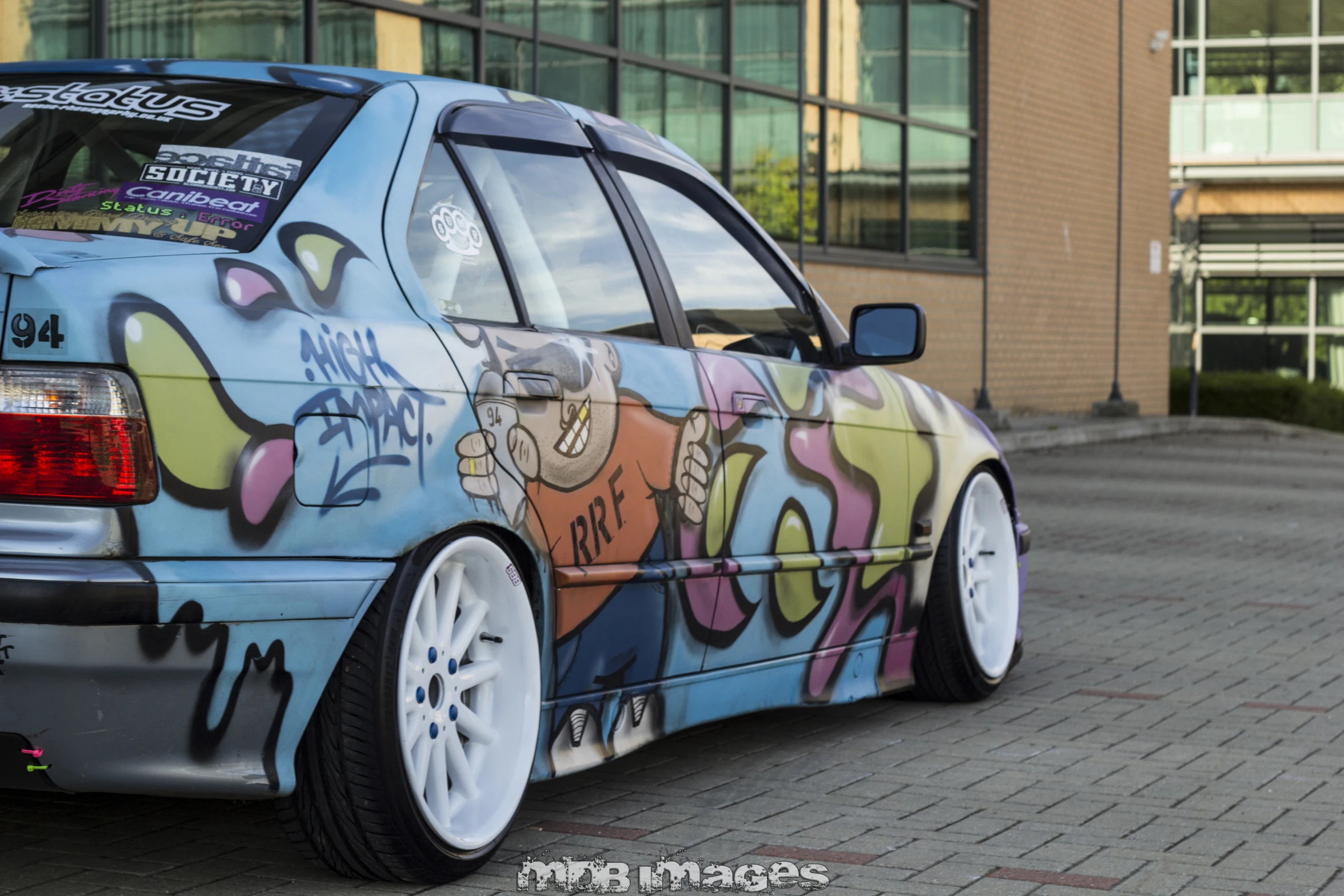 a bmw car with graffiti painted on the rear