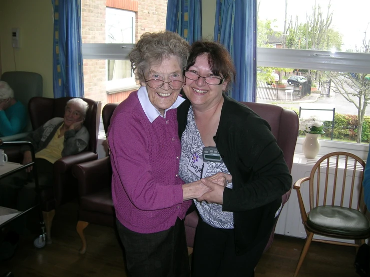 two women hugging in a large living room