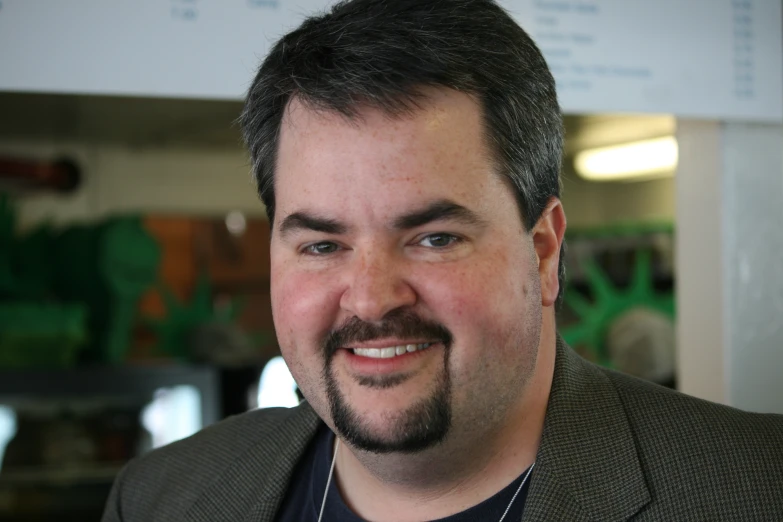 a middle aged man with dark hair wearing a suit jacket