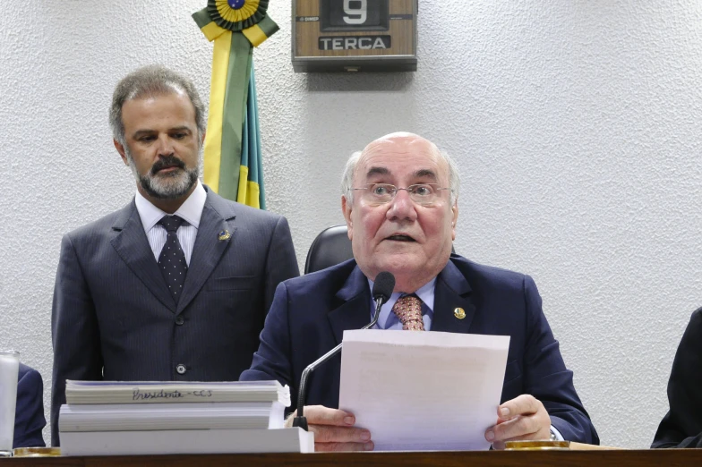 a man standing next to another man at a desk