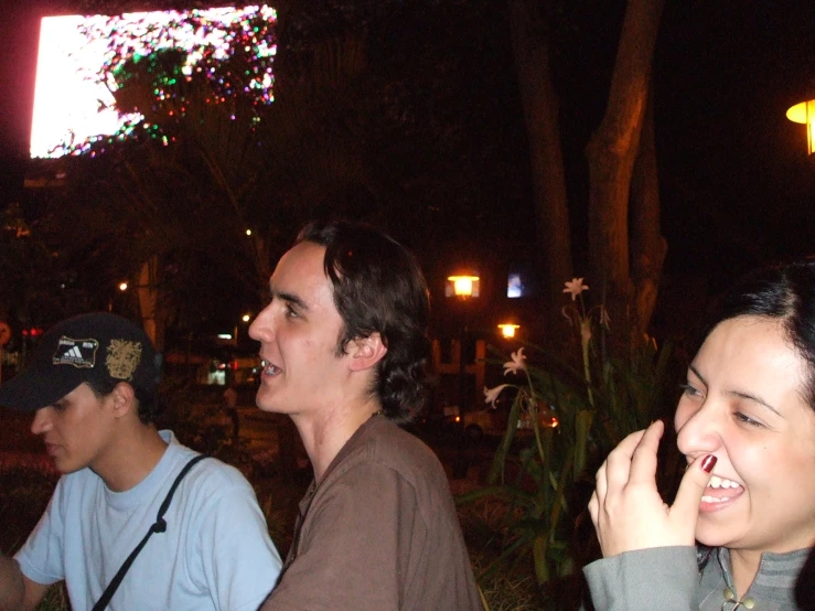 a group of people sitting at a table in front of a screen