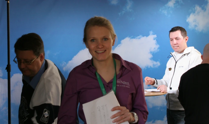 three people standing around and one is holding a book