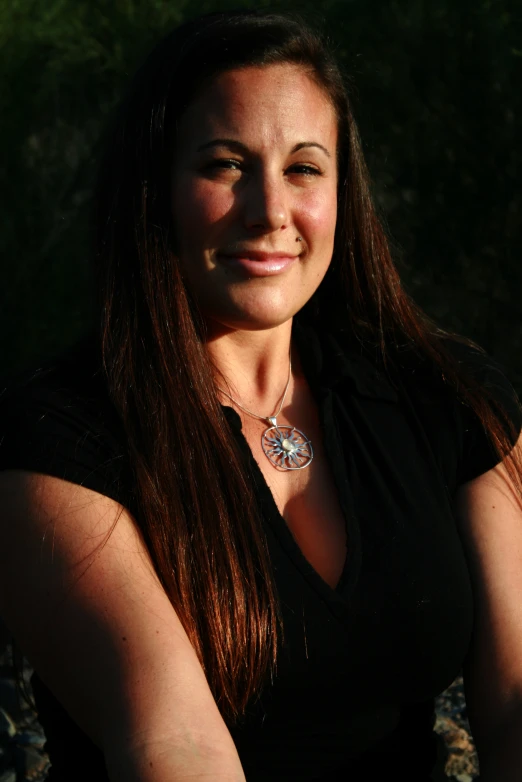 a woman with long brown hair smiles for the camera