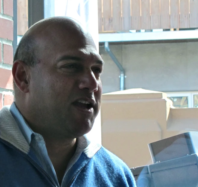 a man in blue shirt talking on a microphone