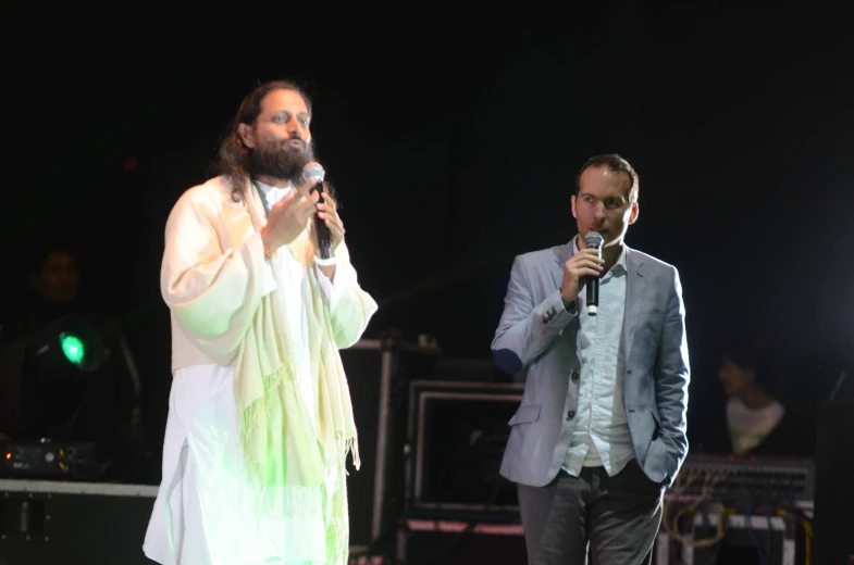 the couple of people are standing together at a concert