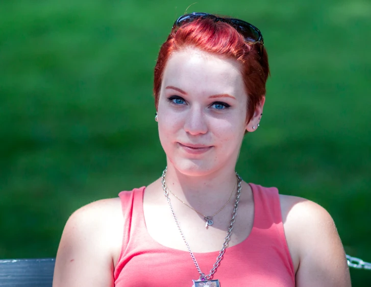 a girl wearing sunglasses is sitting on a bench