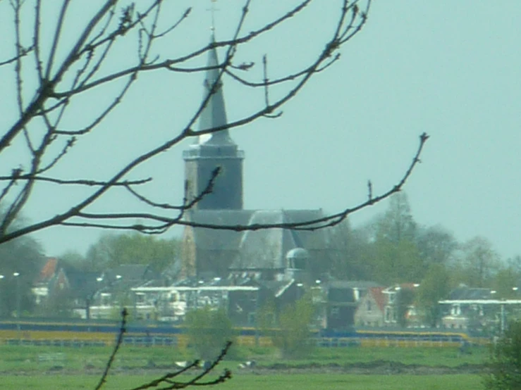 the church with tall spire and green field