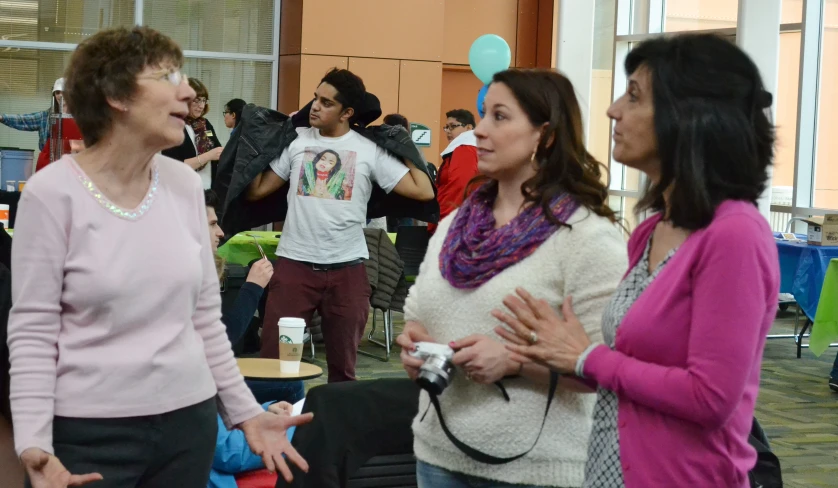 two woman talking with one another in the background