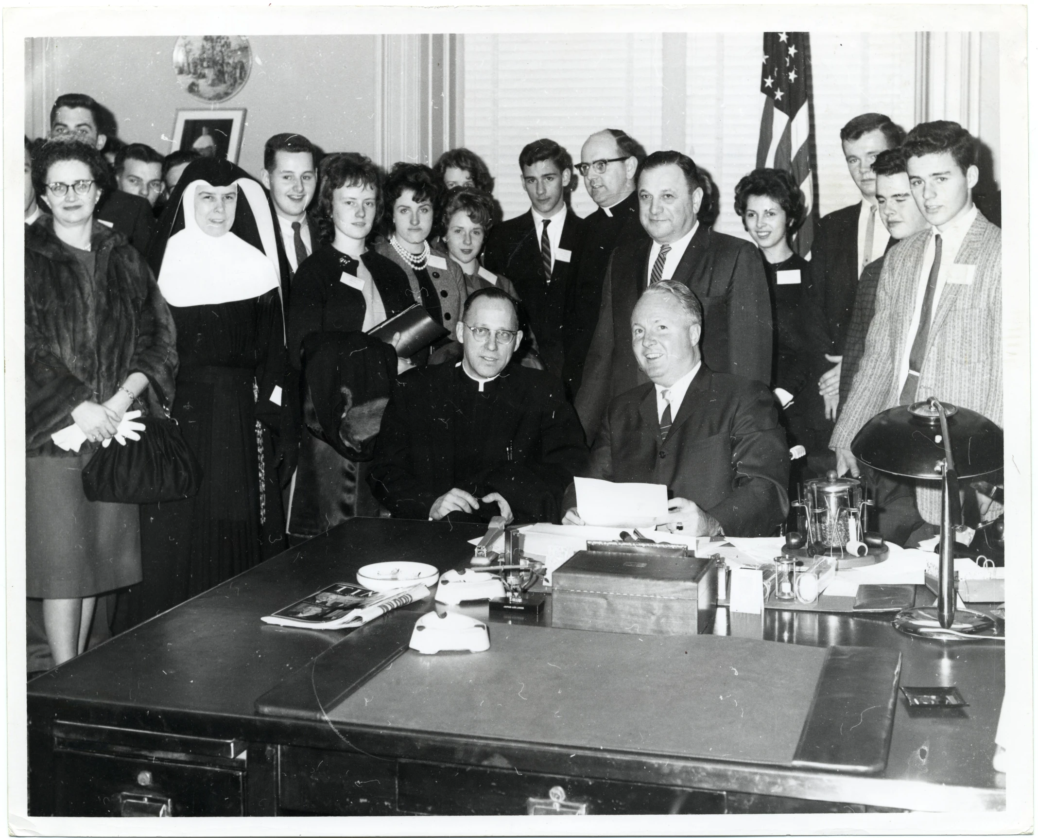 black and white pograph of some people at a desk