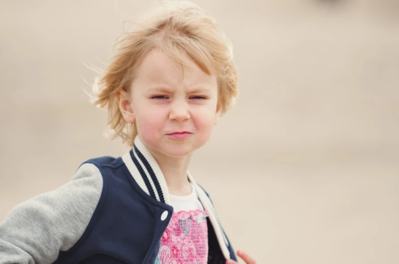 a toddler holding onto an umbrella near the water