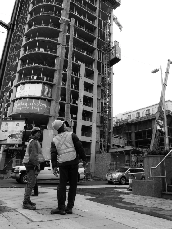 people standing outside in the street looking at a large building