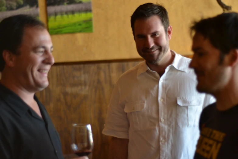 two men smiling and standing in a restaurant