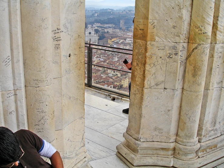 an open doorway overlooking the city below and a man in a brown shirt